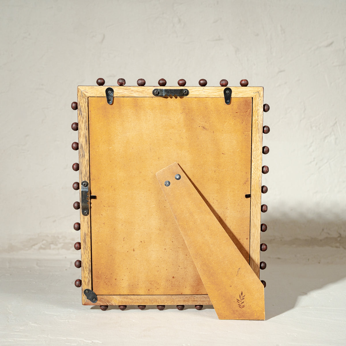 Burgundy beaded wooden tabletop photo frame holding an 8 by 10 inch photograph