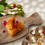 Matsya fish-shaped wooden serving platters styled with snacks and flowers