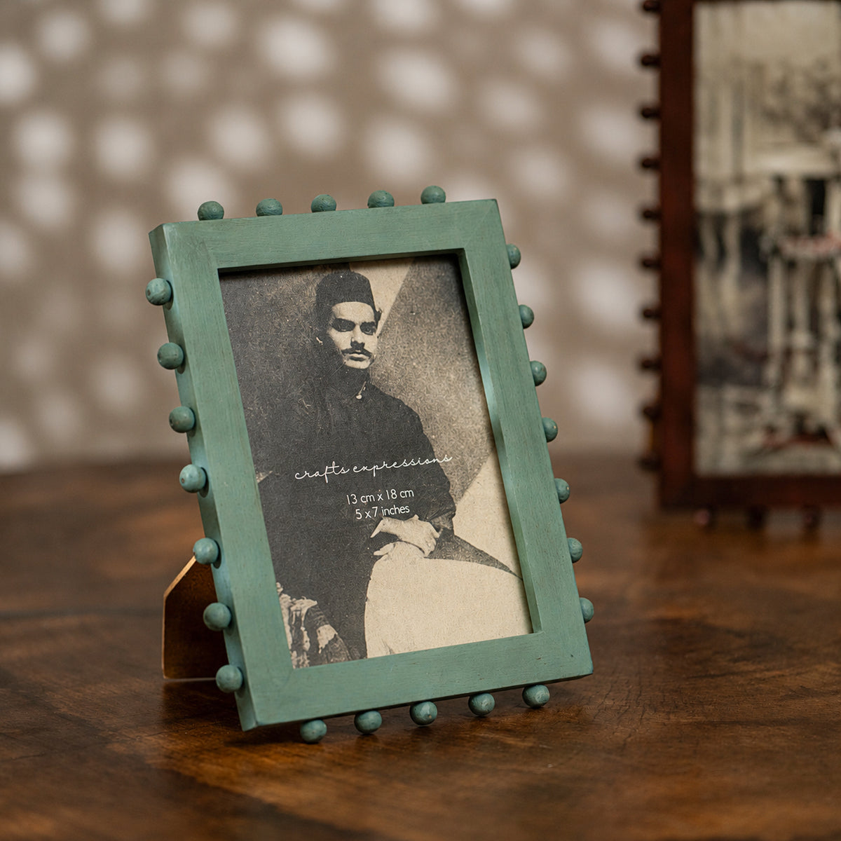 Aqua green beaded wooden tabletop photo frame holding a 5 by 7 inch photograph