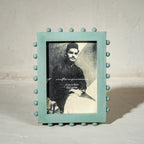 Aqua green beaded wooden tabletop photo frame holding a 5 by 7 inch photograph