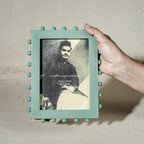 Aqua green beaded wooden tabletop photo frame holding a 5 by 7 inch photograph