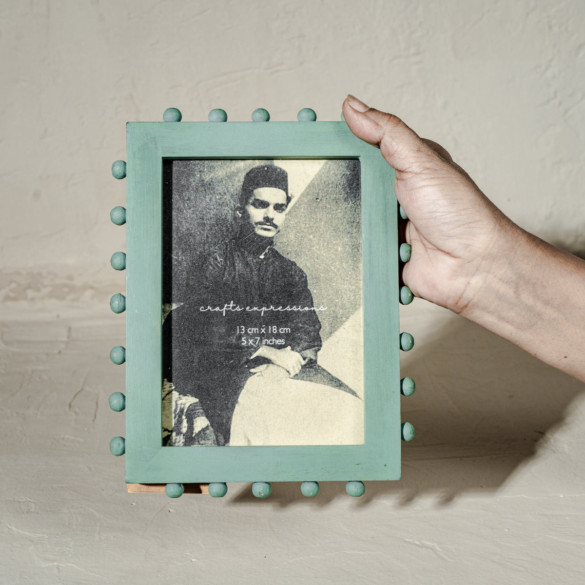 Aqua green beaded wooden tabletop photo frame holding a 5 by 7 inch photograph