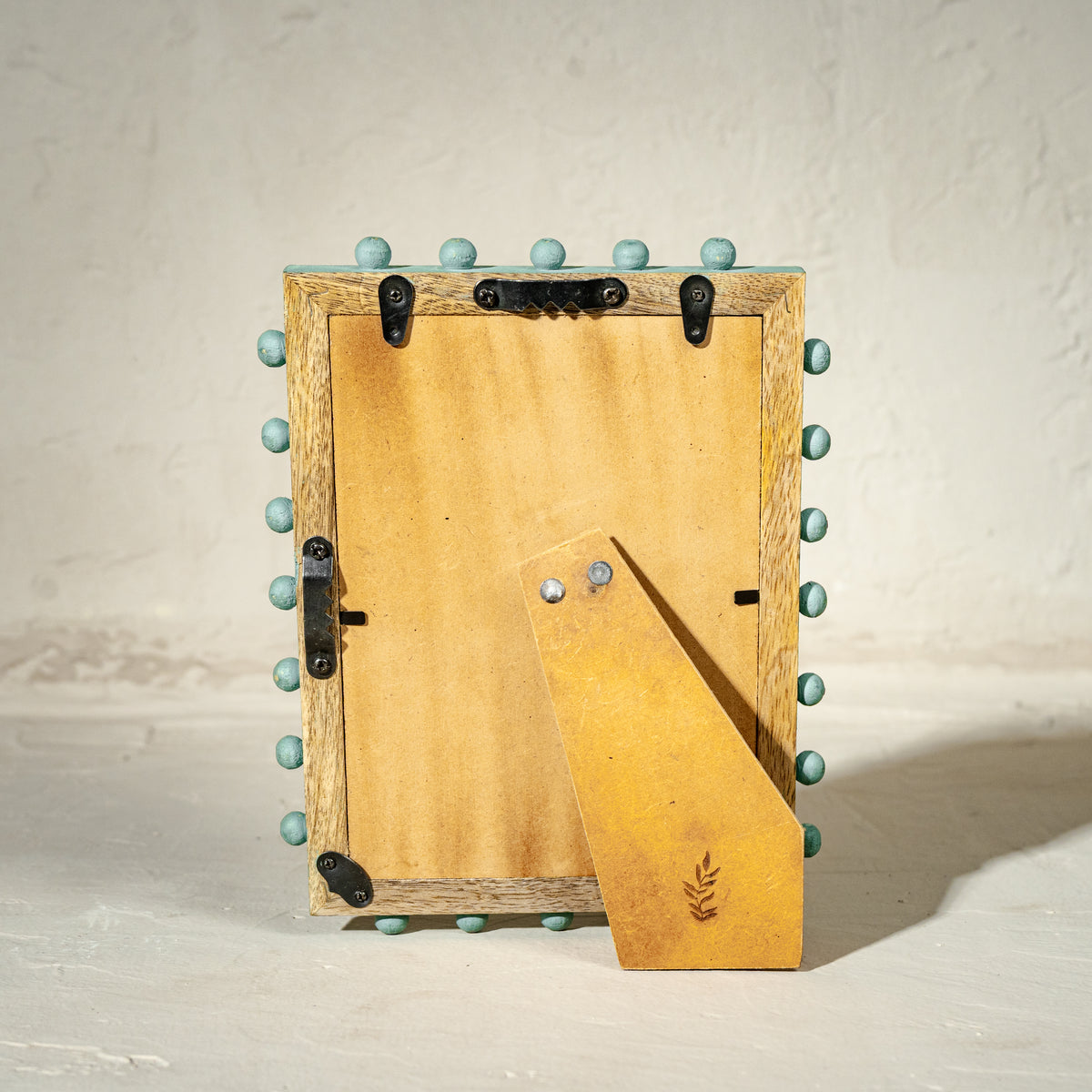 Aqua green beaded wooden tabletop photo frame holding a 5 by 7 inch photograph