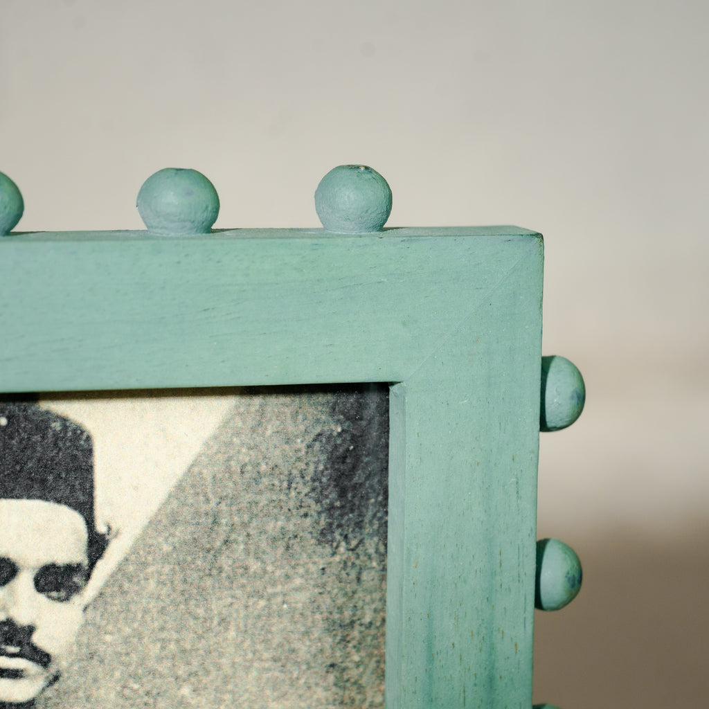 Aqua green beaded wooden tabletop photo frame holding a 5 by 7 inch photograph
