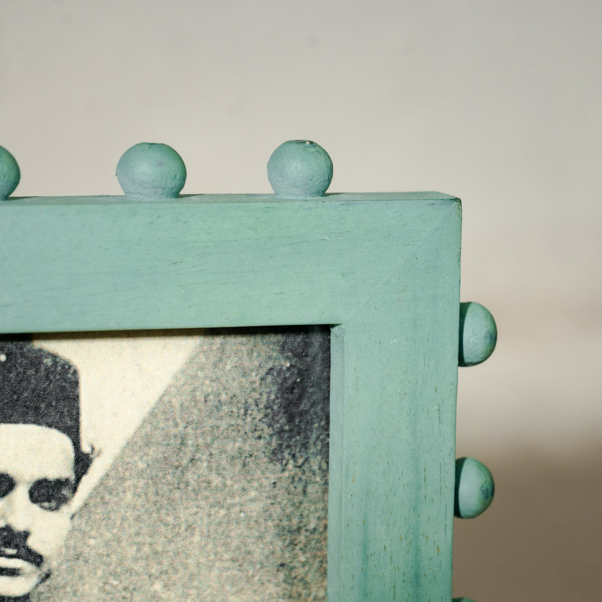 Aqua green beaded wooden tabletop photo frame holding a 5 by 7 inch photograph