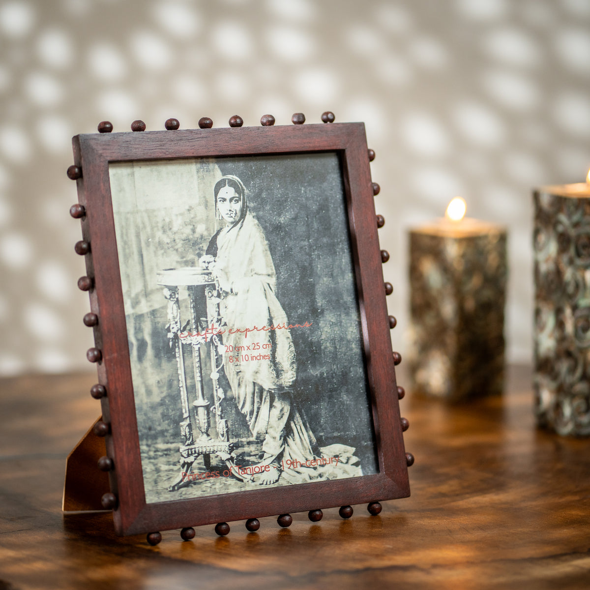 Burgundy beaded wooden tabletop photo frame holding an 8 by 10 inch photograph