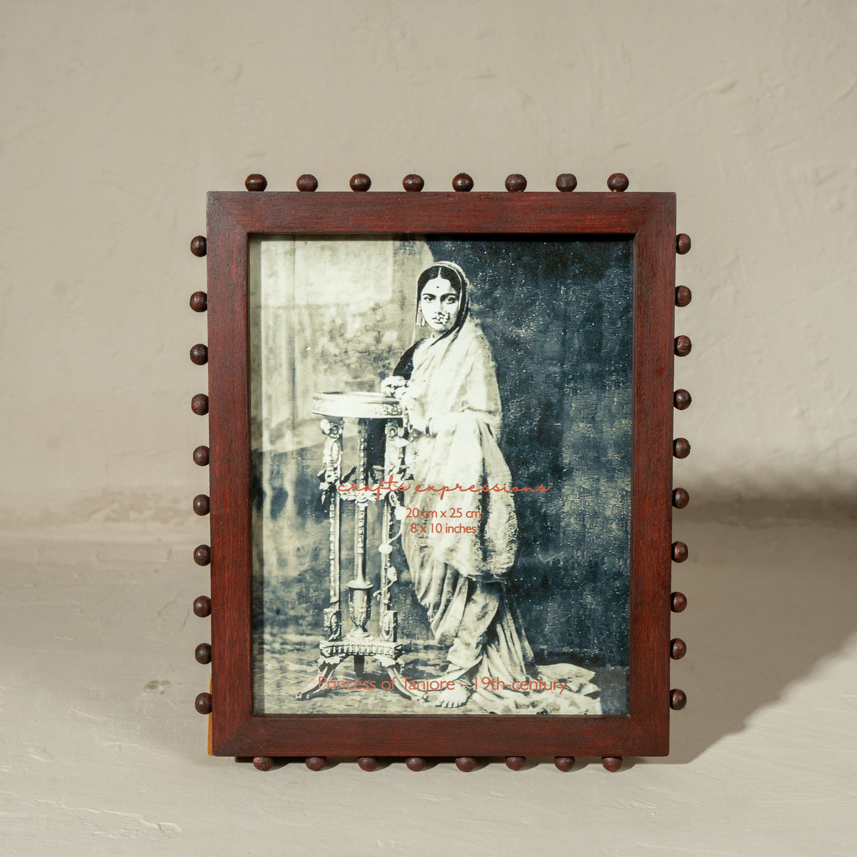 Burgundy beaded wooden tabletop photo frame holding an 8 by 10 inch photograph