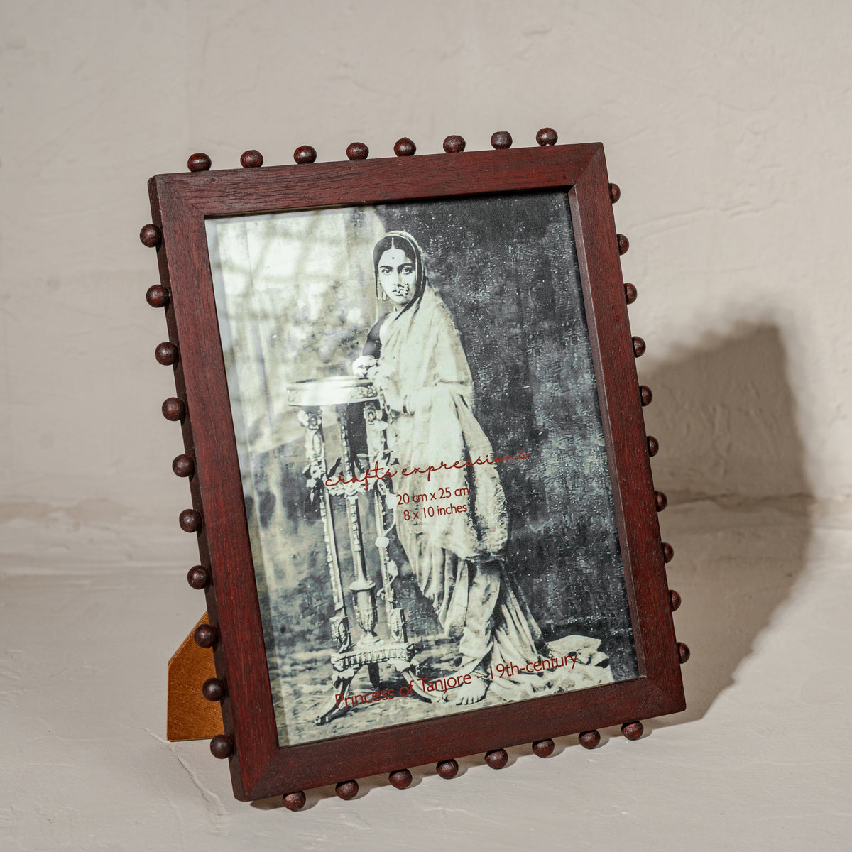 Burgundy beaded wooden tabletop photo frame holding an 8 by 10 inch photograph
