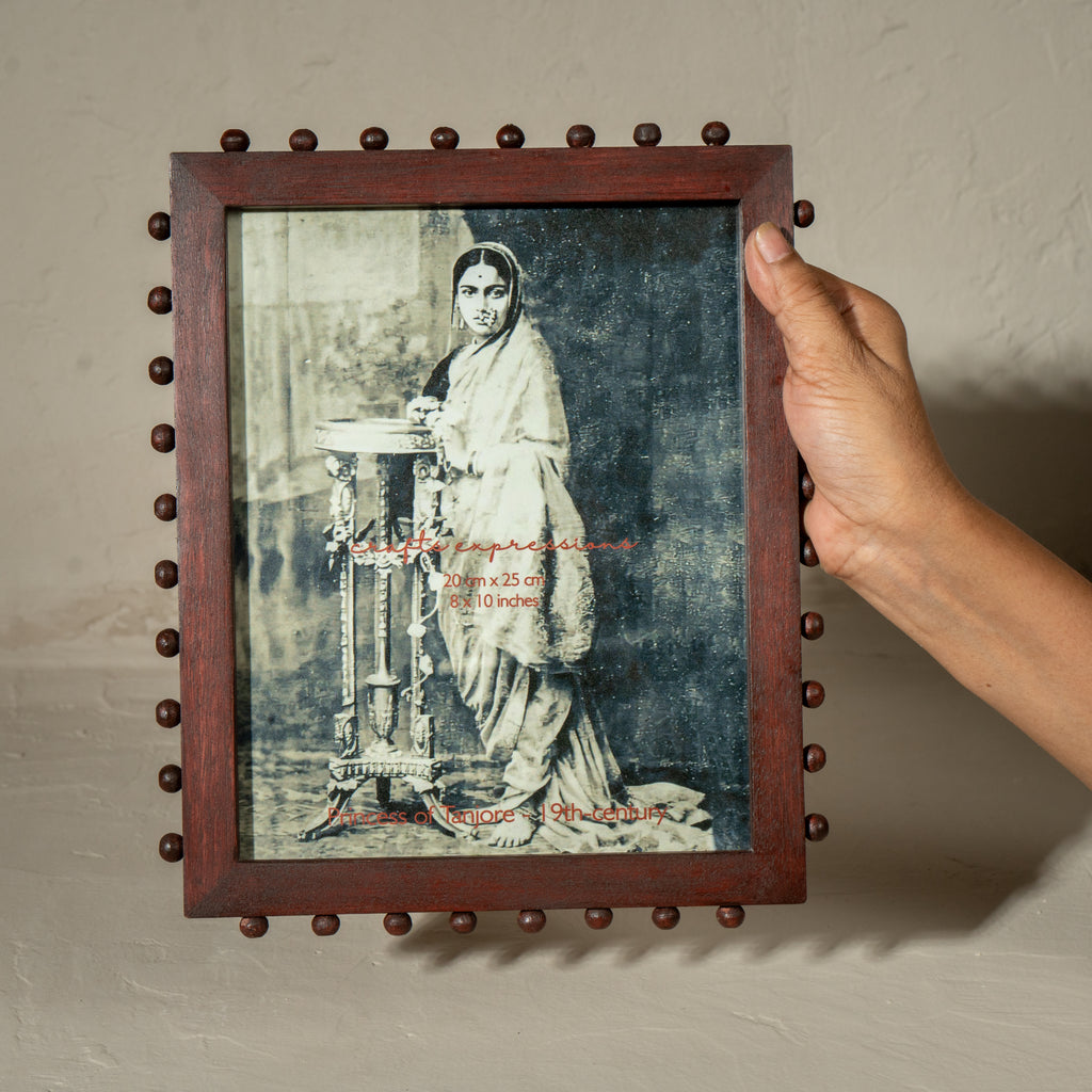 Burgundy beaded wooden tabletop photo frame holding an 8 by 10 inch photograph