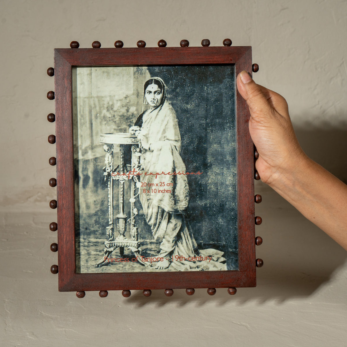 Burgundy beaded wooden tabletop photo frame holding an 8 by 10 inch photograph