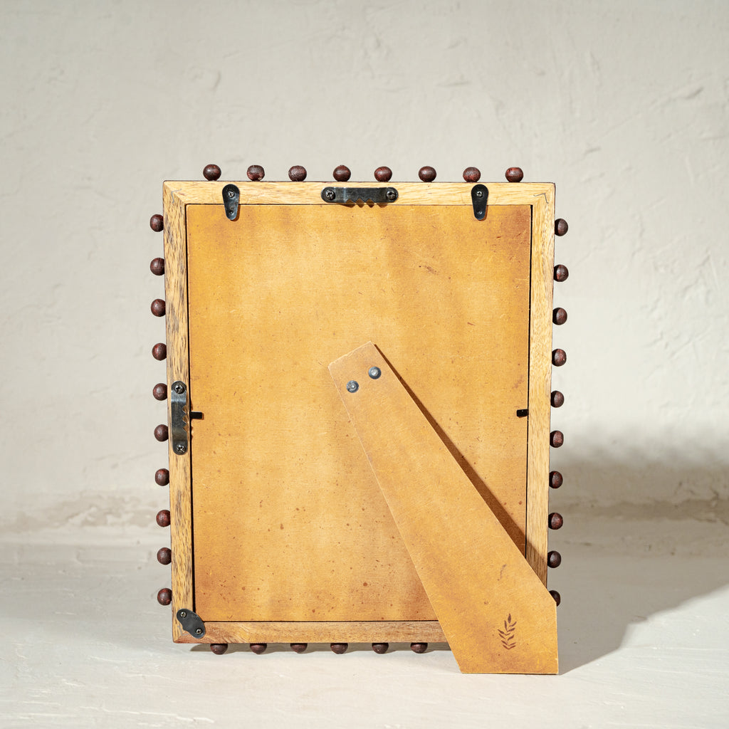Burgundy beaded wooden tabletop photo frame holding an 8 by 10 inch photograph