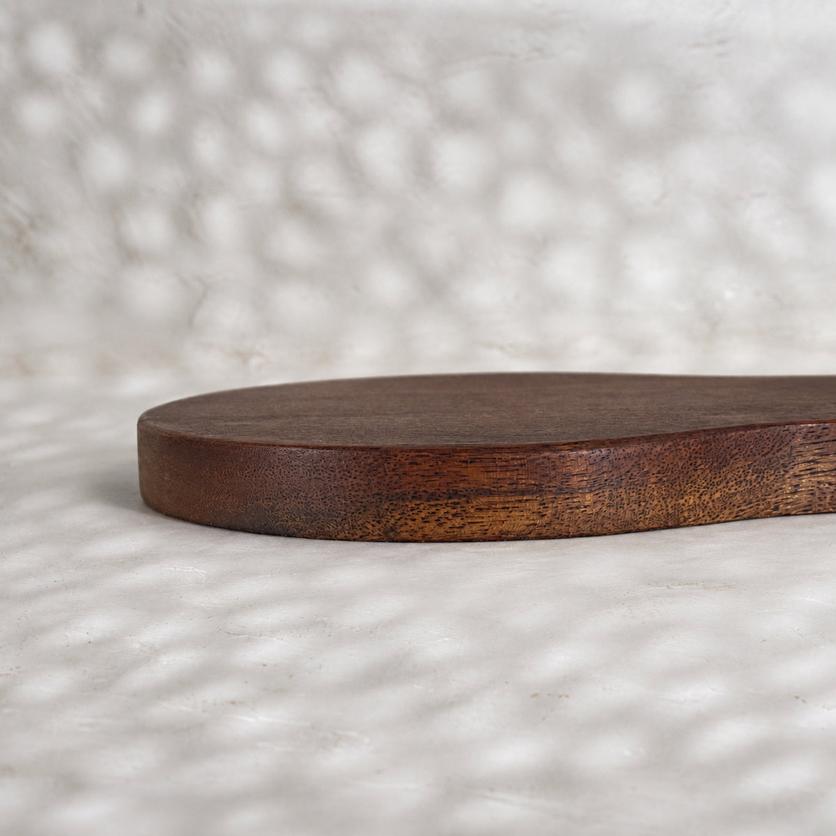 Close-up side view of the Orchard pear-shaped wooden trivet