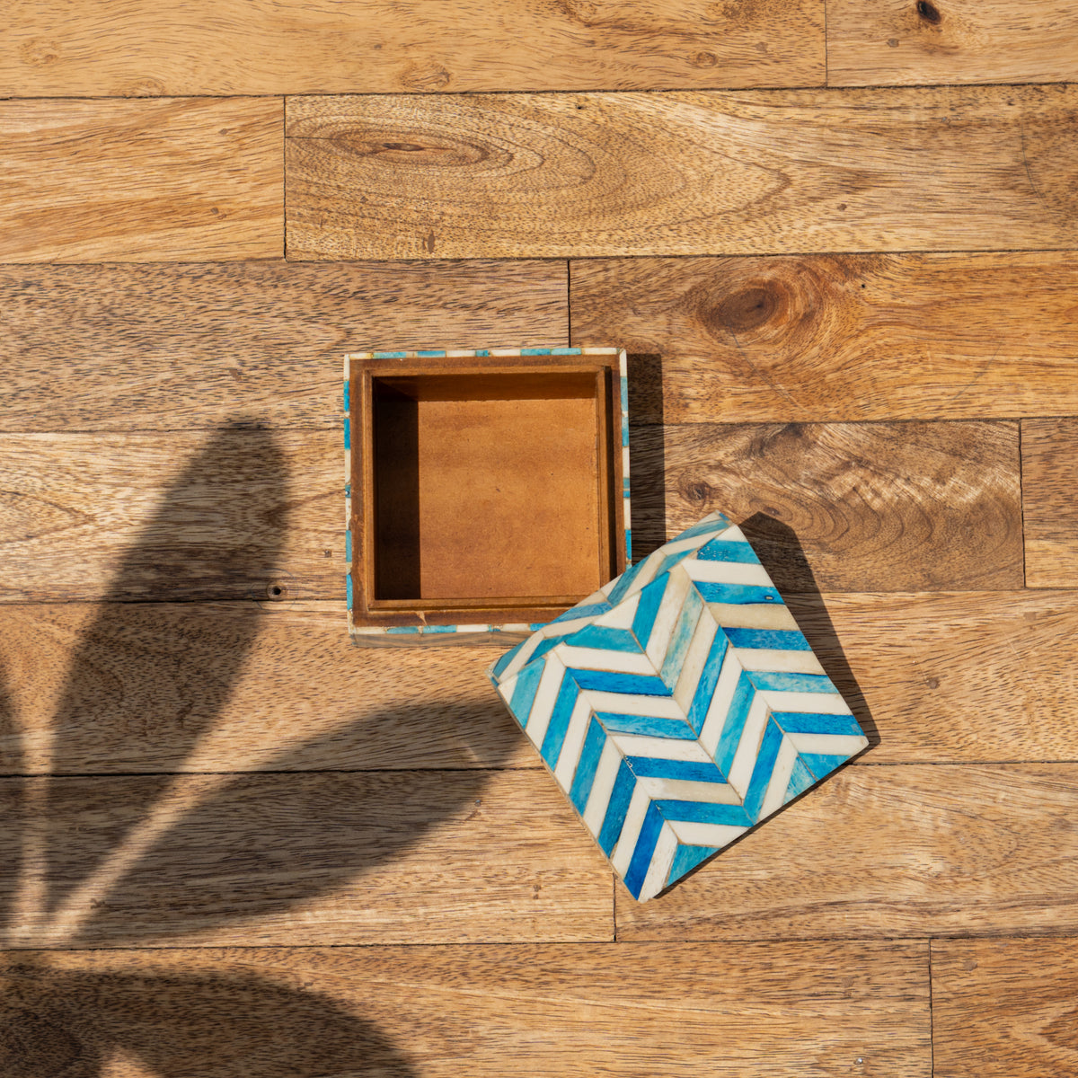 Open Chevron wooden storage box with patterned lid beside it