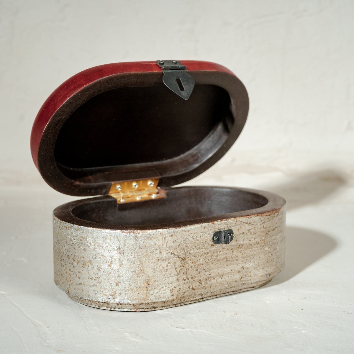 Warm-silver and red oval wooden jewellery box with an open lid
