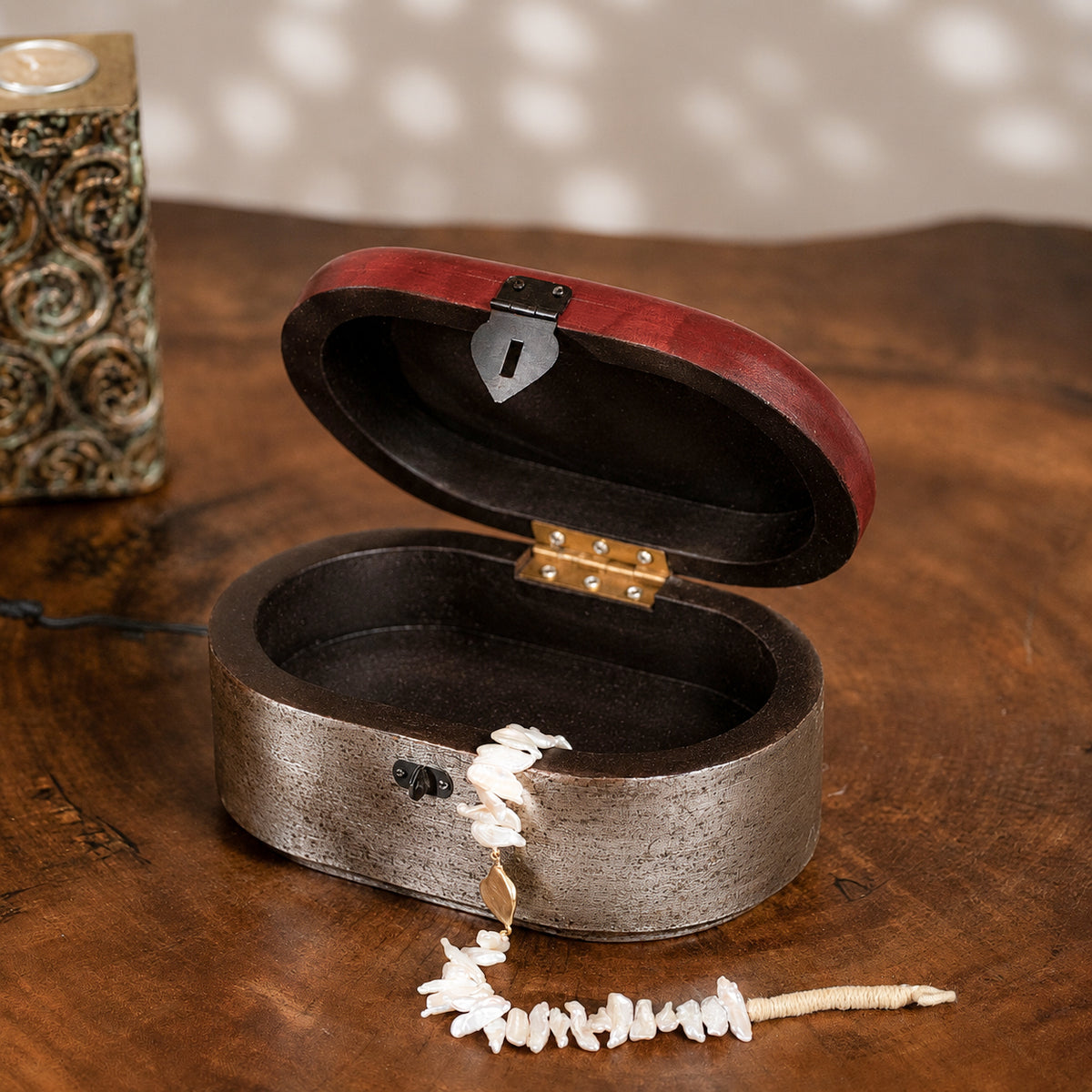 Warm-silver and red oval wooden jewellery box with an open lid