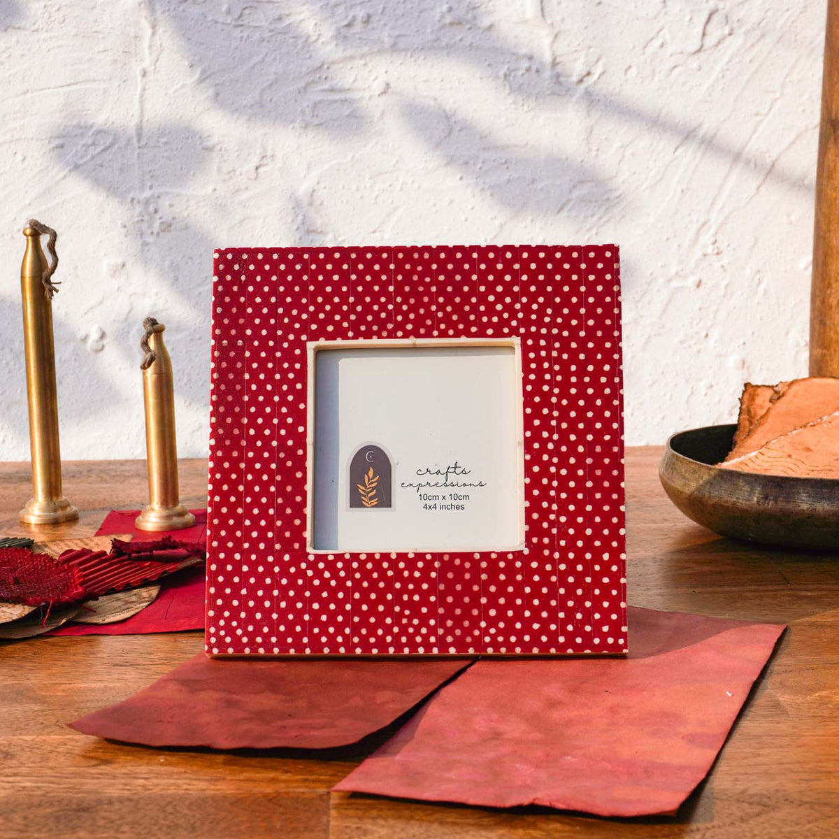 Warm red Dottie square photo frame styled with brass décor