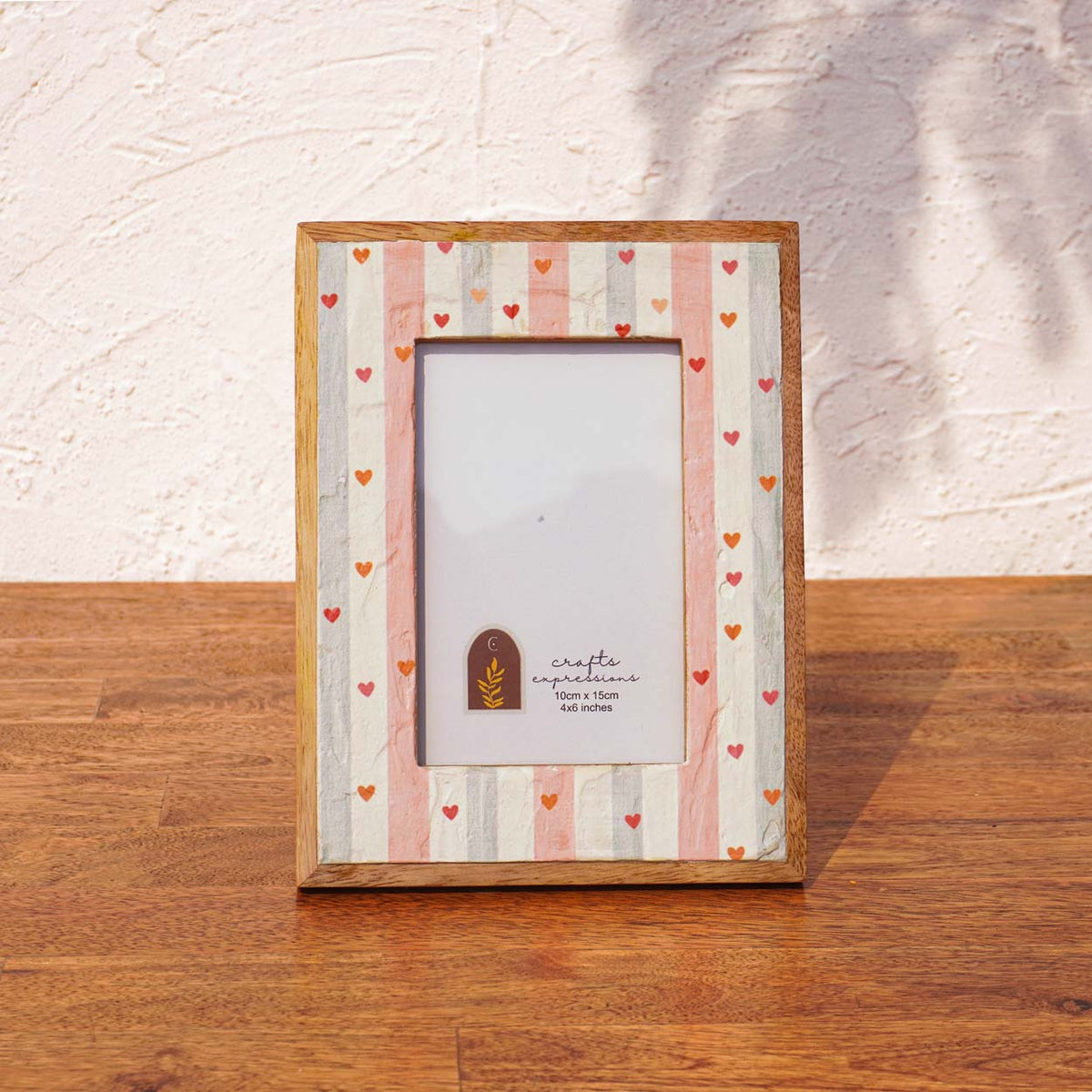 Front view of the Little Hearts wooden photo frame in soft peach and mint