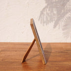 Side view of the Baby Blue wooden photo frame supported by its easel stand