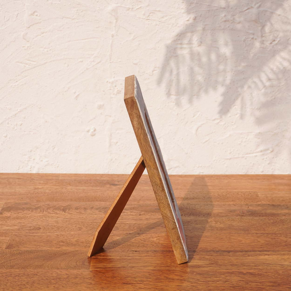Side view of the Baby Blue wooden photo frame supported by its easel stand