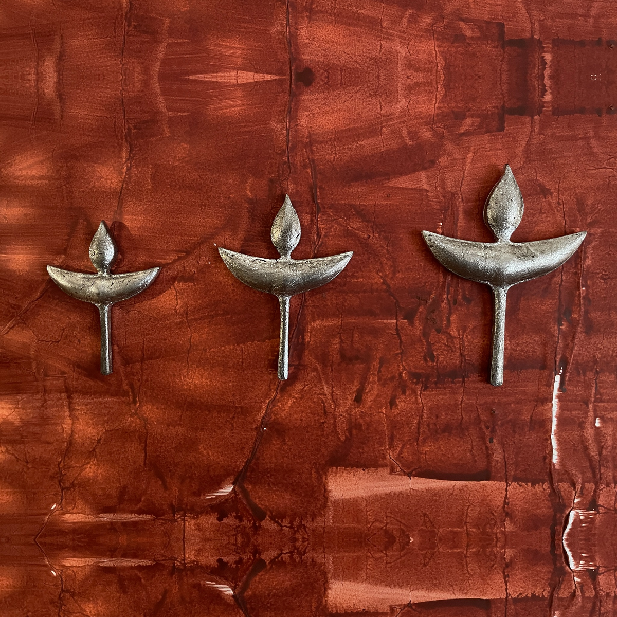 Three Nuri diya-shaped wooden wall decorations displayed together