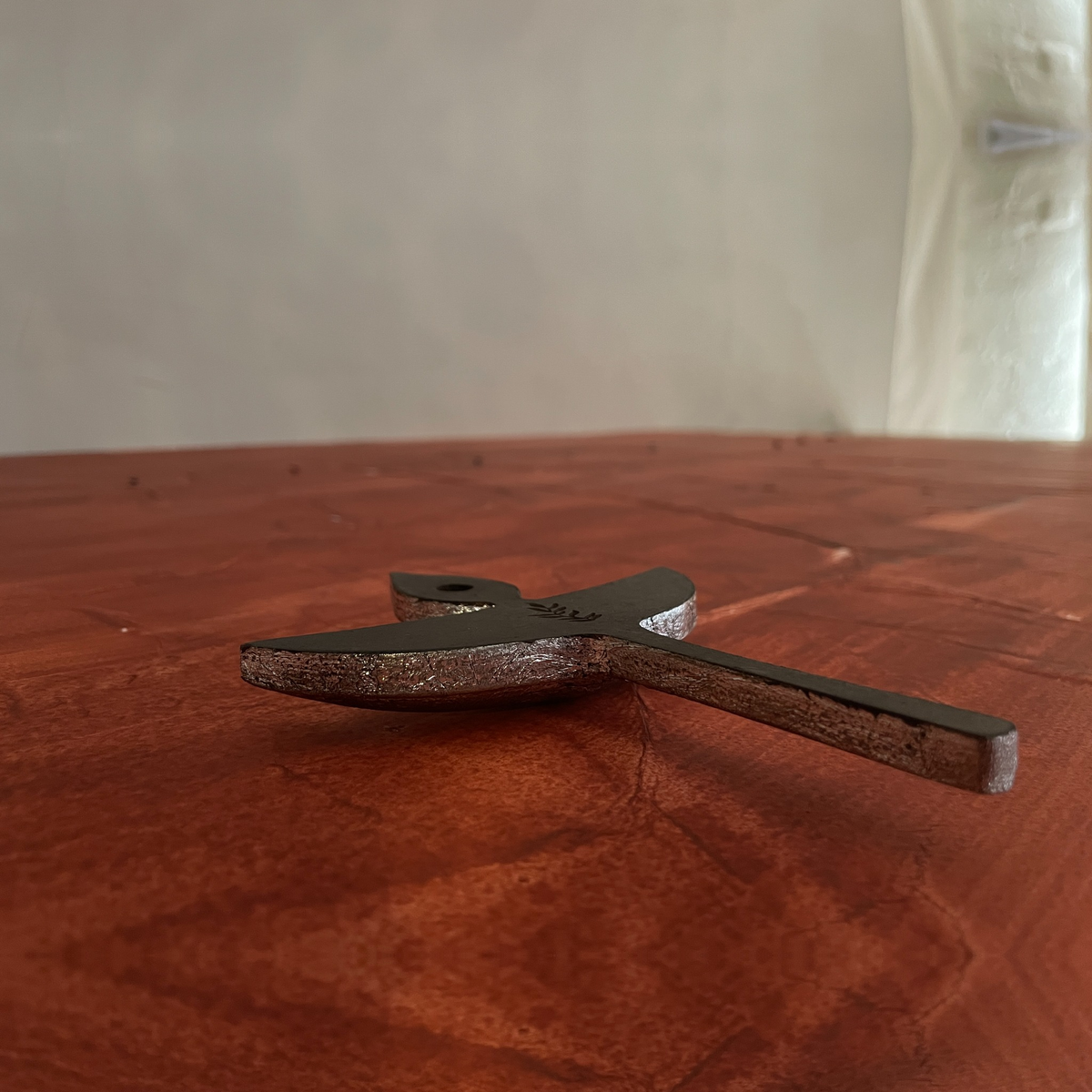 Side view of two Nuri diya-shaped wooden wall decorations