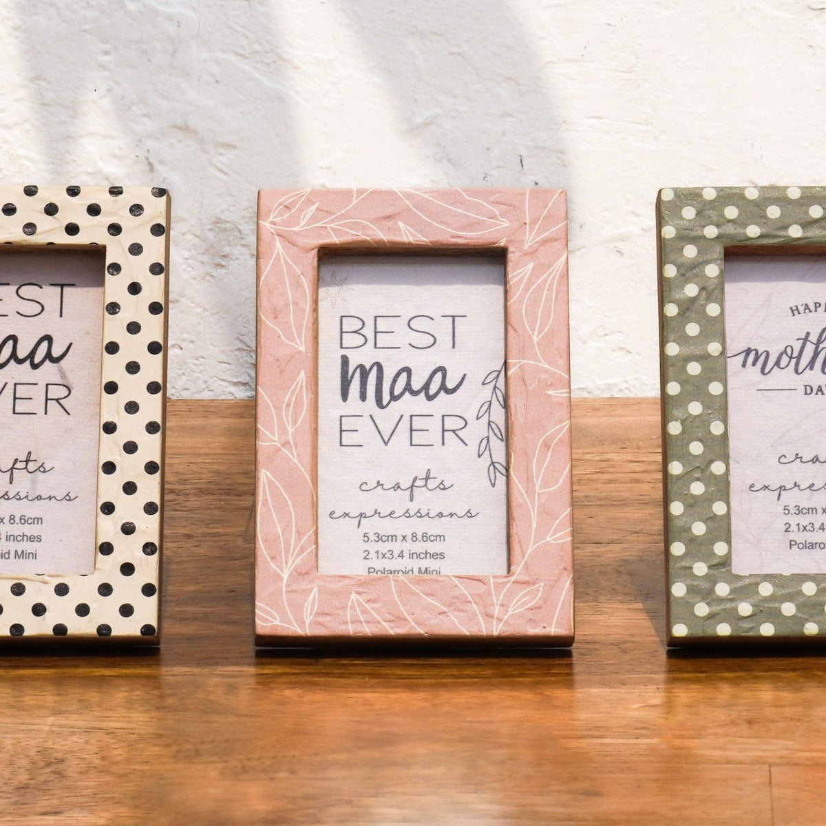 Close-up of Dots & Petals wooden Instax Mini frames in white, pink and olive