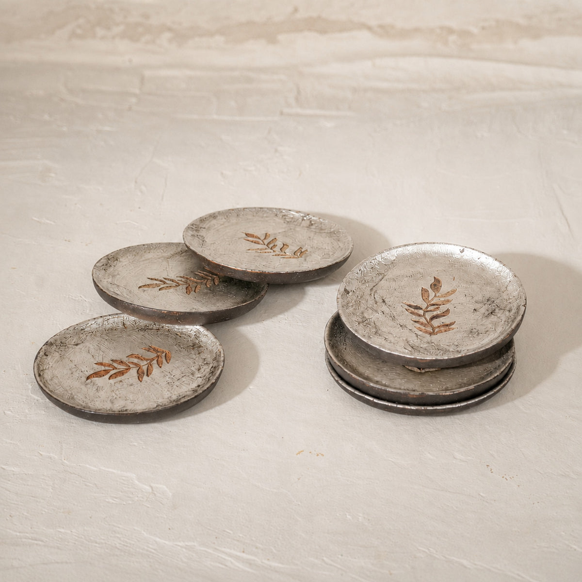 Set of six round wooden coasters with distressed finish and rust botanical motifs