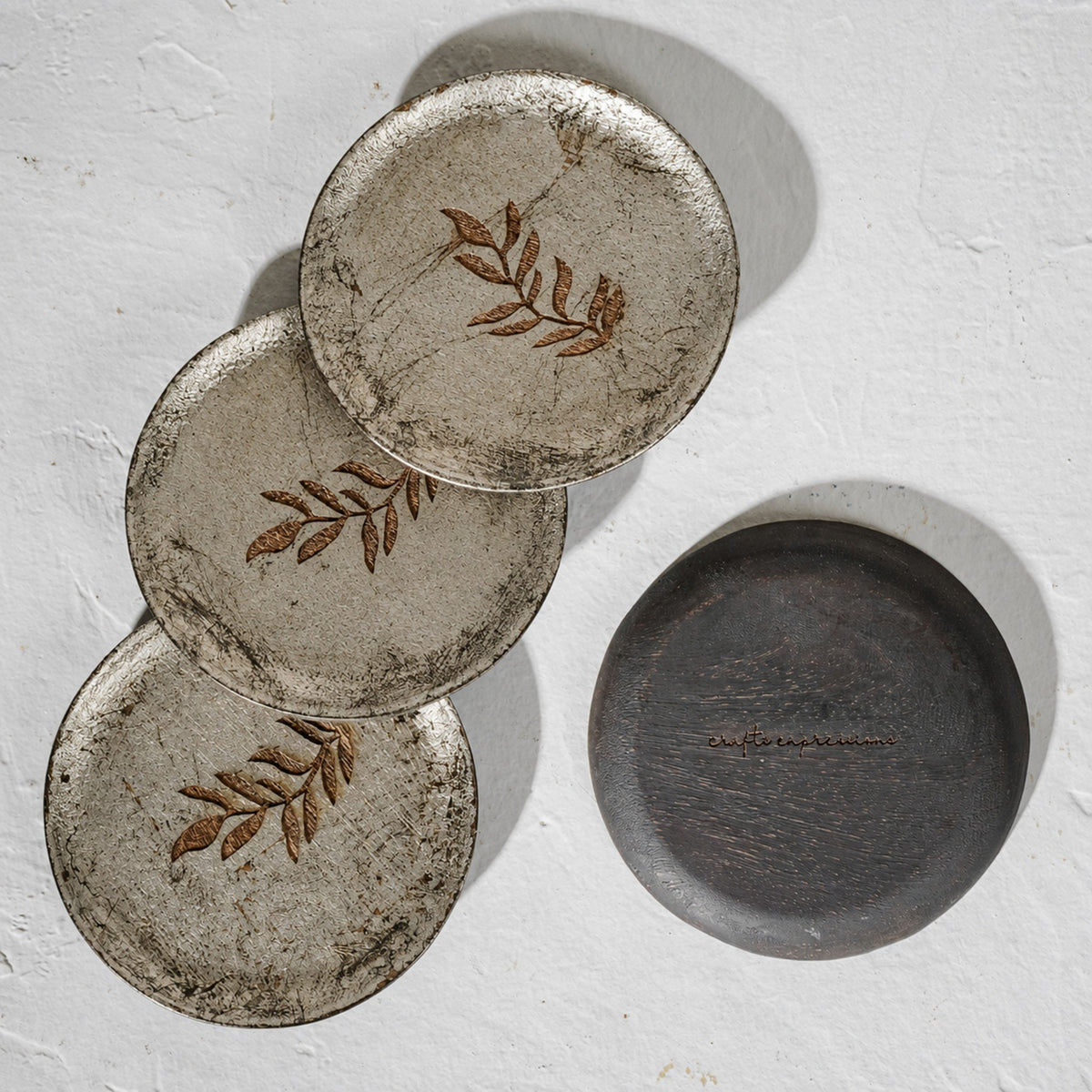 Set of six round wooden coasters with distressed finish and rust botanical motifs
