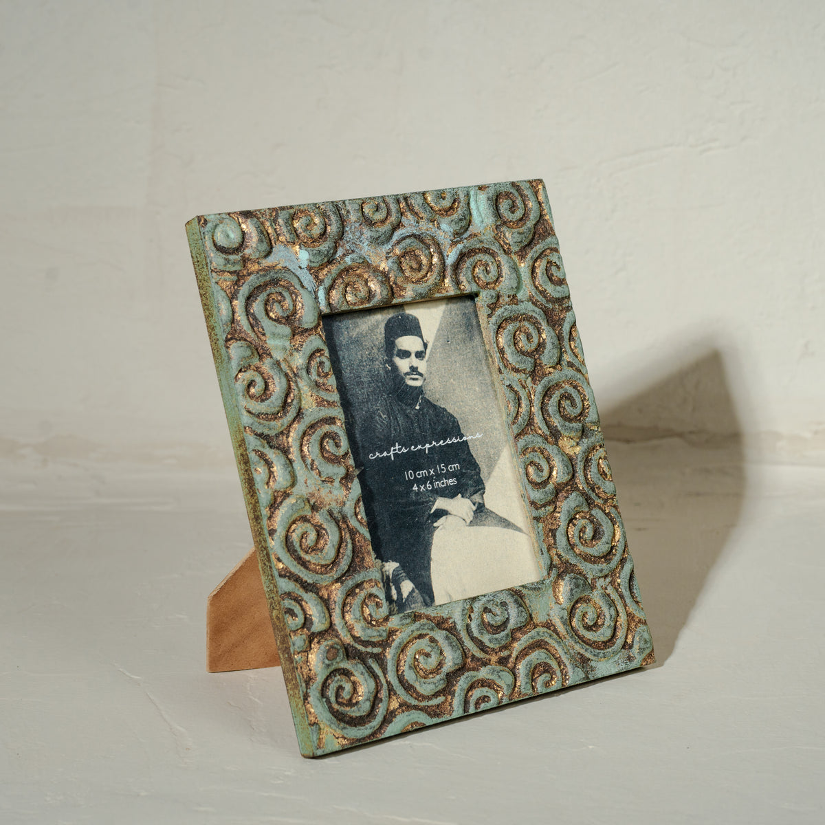 Carved gold-green wooden photo frame holding a 4 by 6 inch photograph