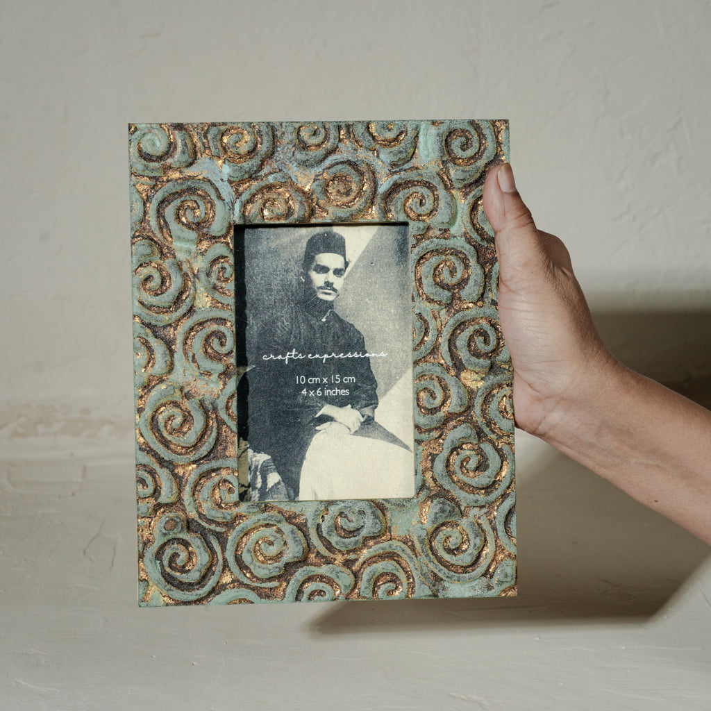 Carved gold-green wooden photo frame holding a 4 by 6 inch photograph