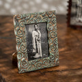 Carved gold-green wooden photo frame holding a 5 by 7 inch photograph