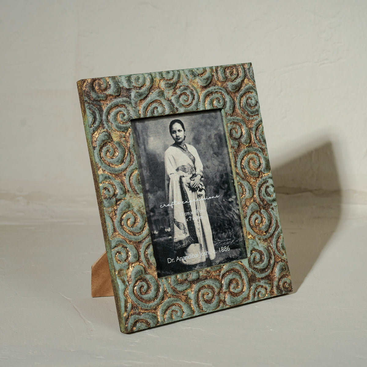 Carved gold-green wooden photo frame holding a 5 by 7 inch photograph
