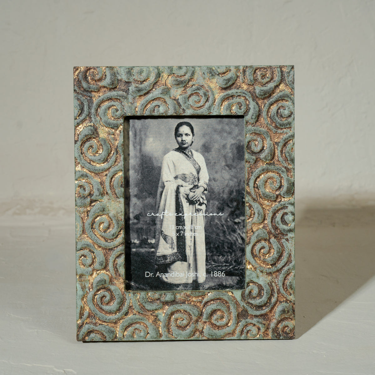 Carved gold-green wooden photo frame holding a 5 by 7 inch photograph