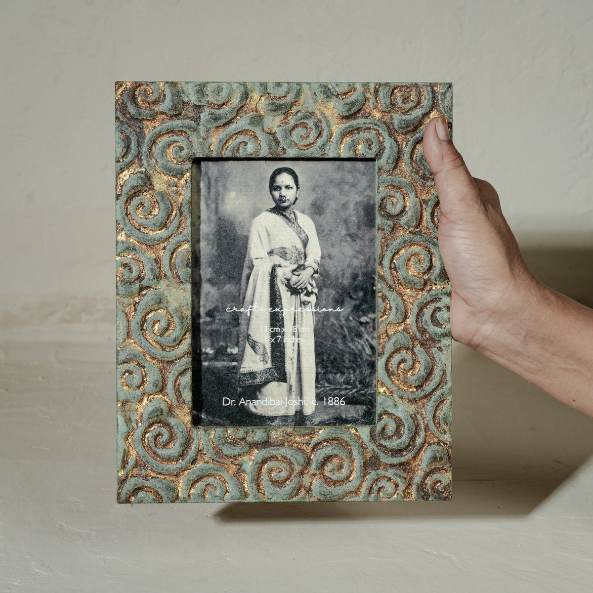 Carved gold-green wooden photo frame holding a 5 by 7 inch photograph