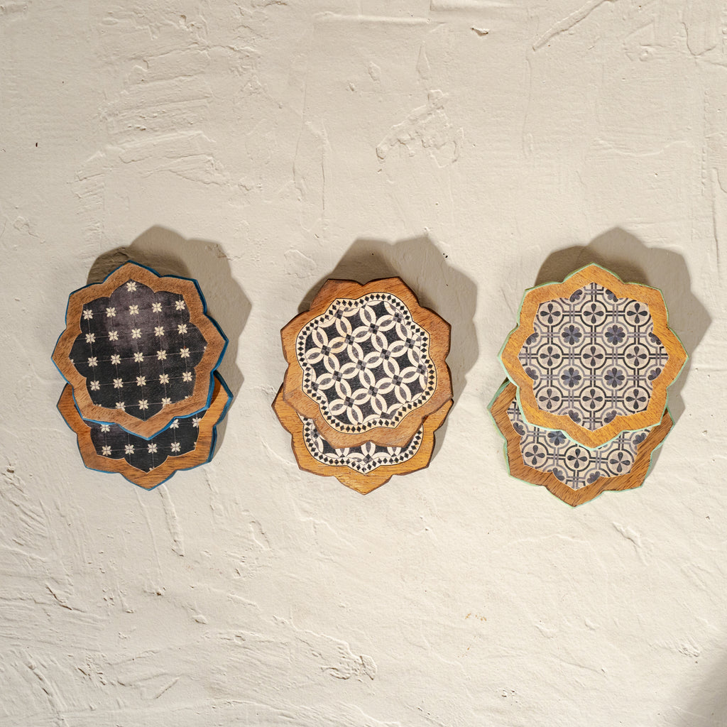 Set of six scalloped wooden coasters with blue embroidery-inspired patterns