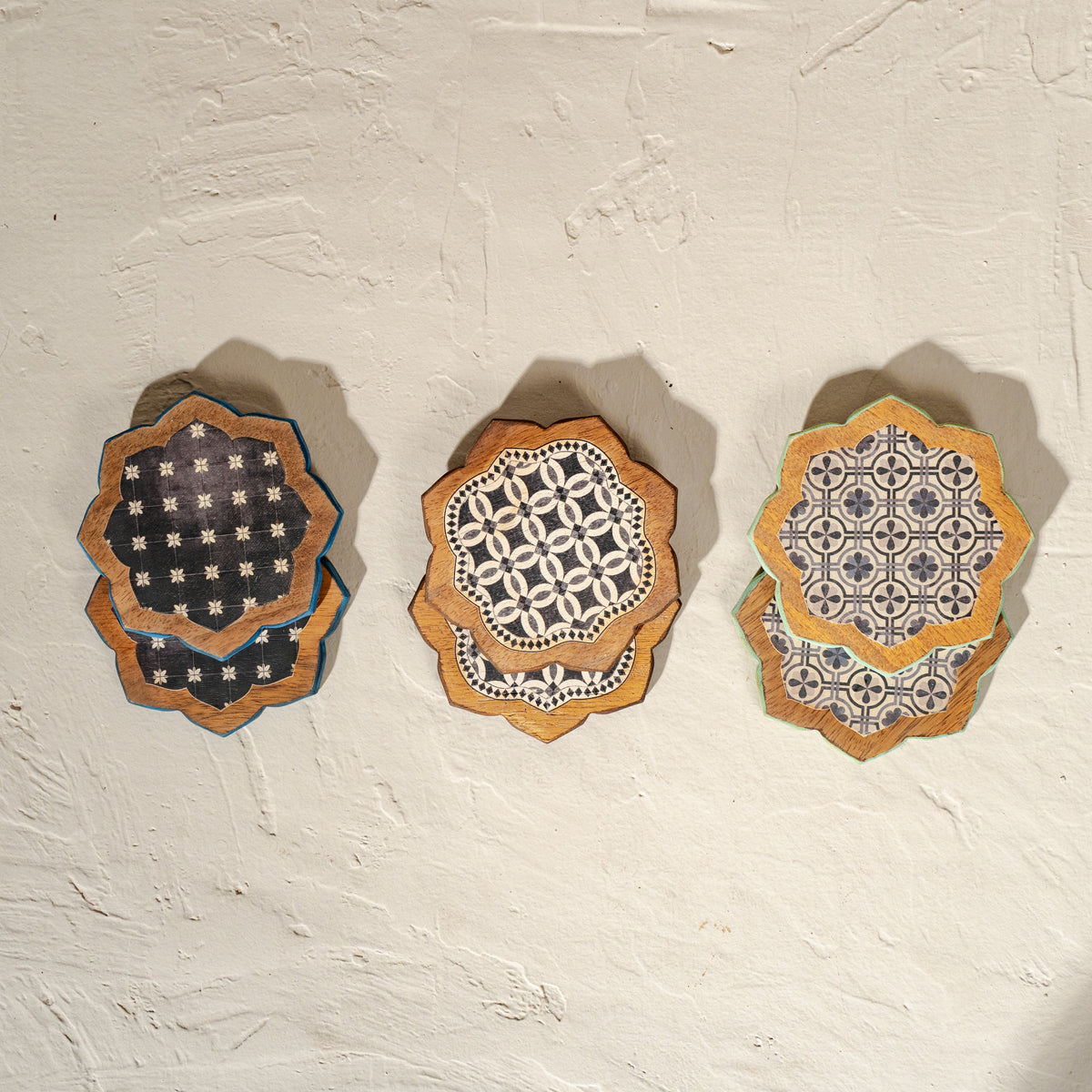 Set of six scalloped wooden coasters with blue embroidery-inspired patterns