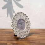 Angled view of the classic white Lotus round photo frame with easel stand