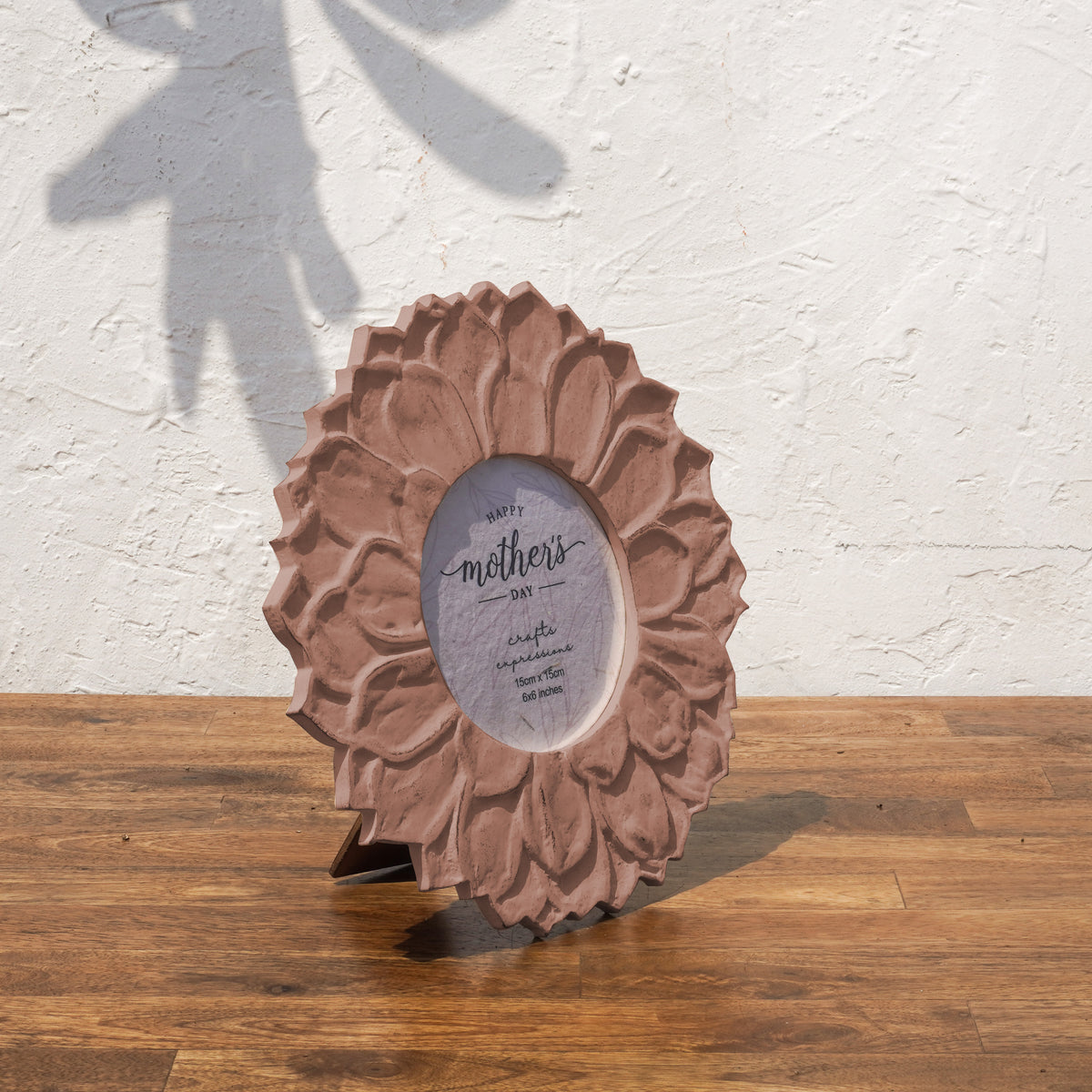 Angled view of the earthy pink Lotus round photo frame with easel stand