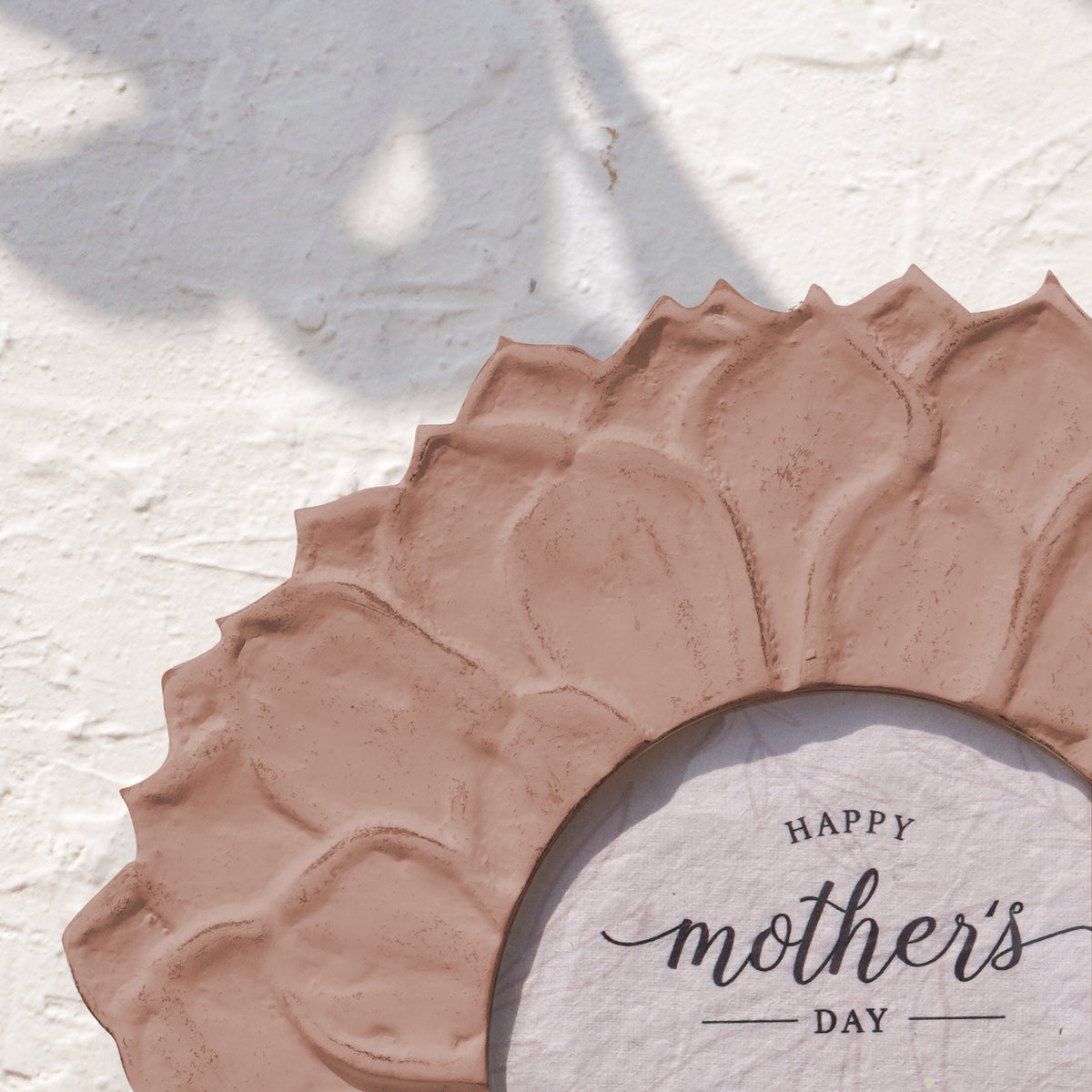 Close-up of the earthy pink lotus-petal detail on the round photo frame
