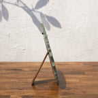 Side view of the olive green Lotus round photo frame with easel stand
