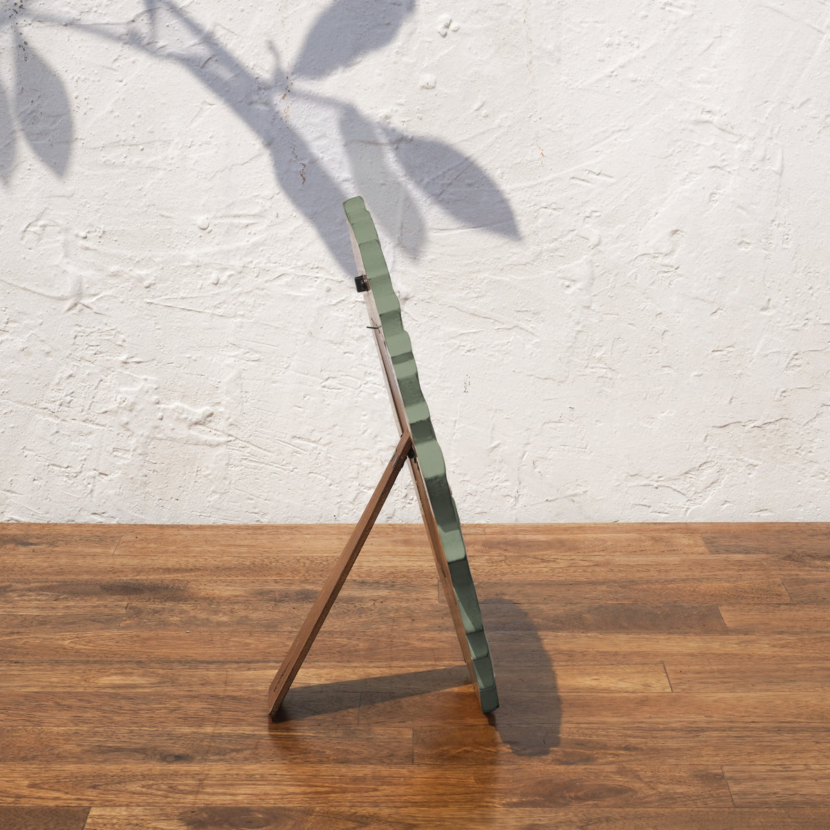 Side view of the olive green Lotus round photo frame with easel stand