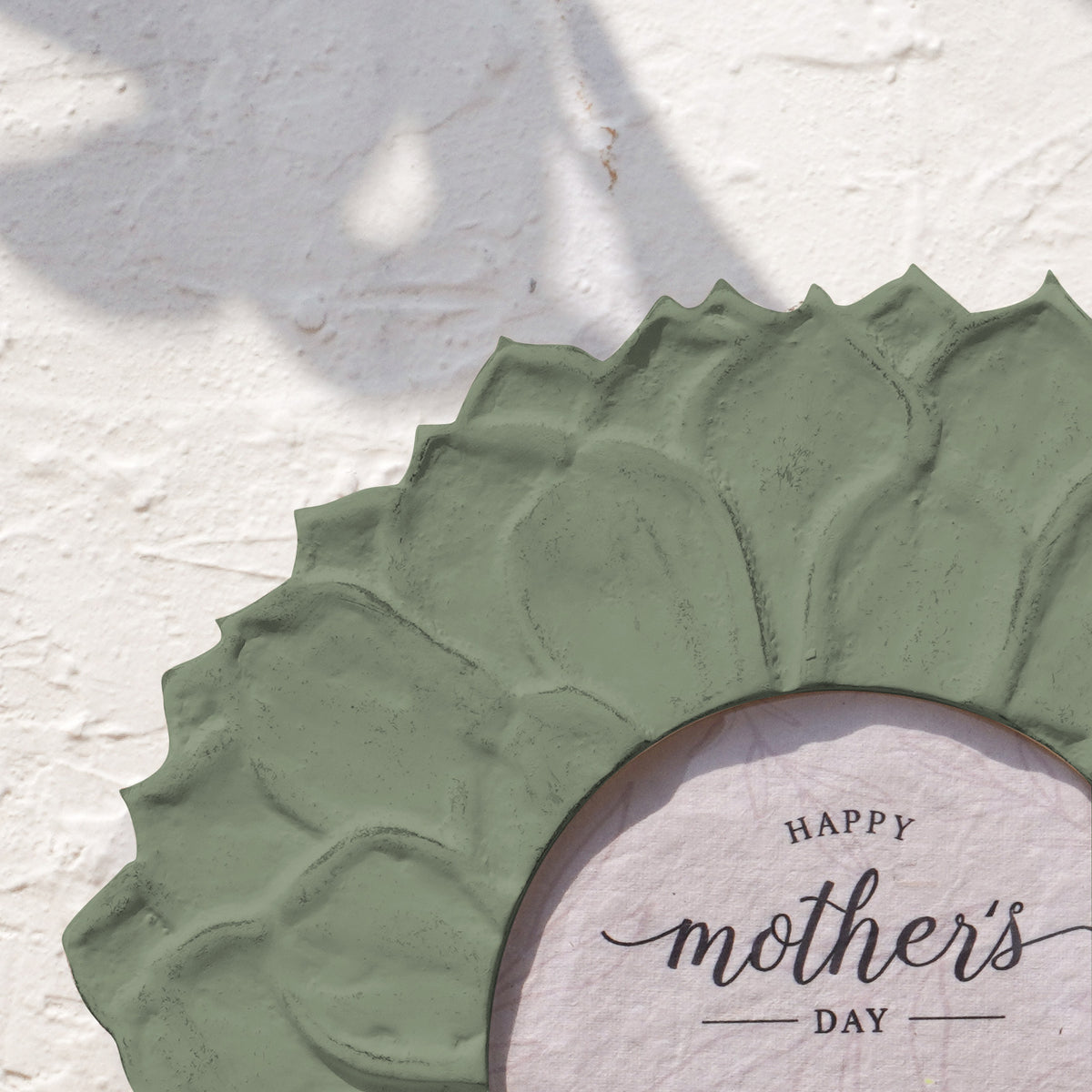 Close-up of the olive green lotus-petal detail on the round photo frame