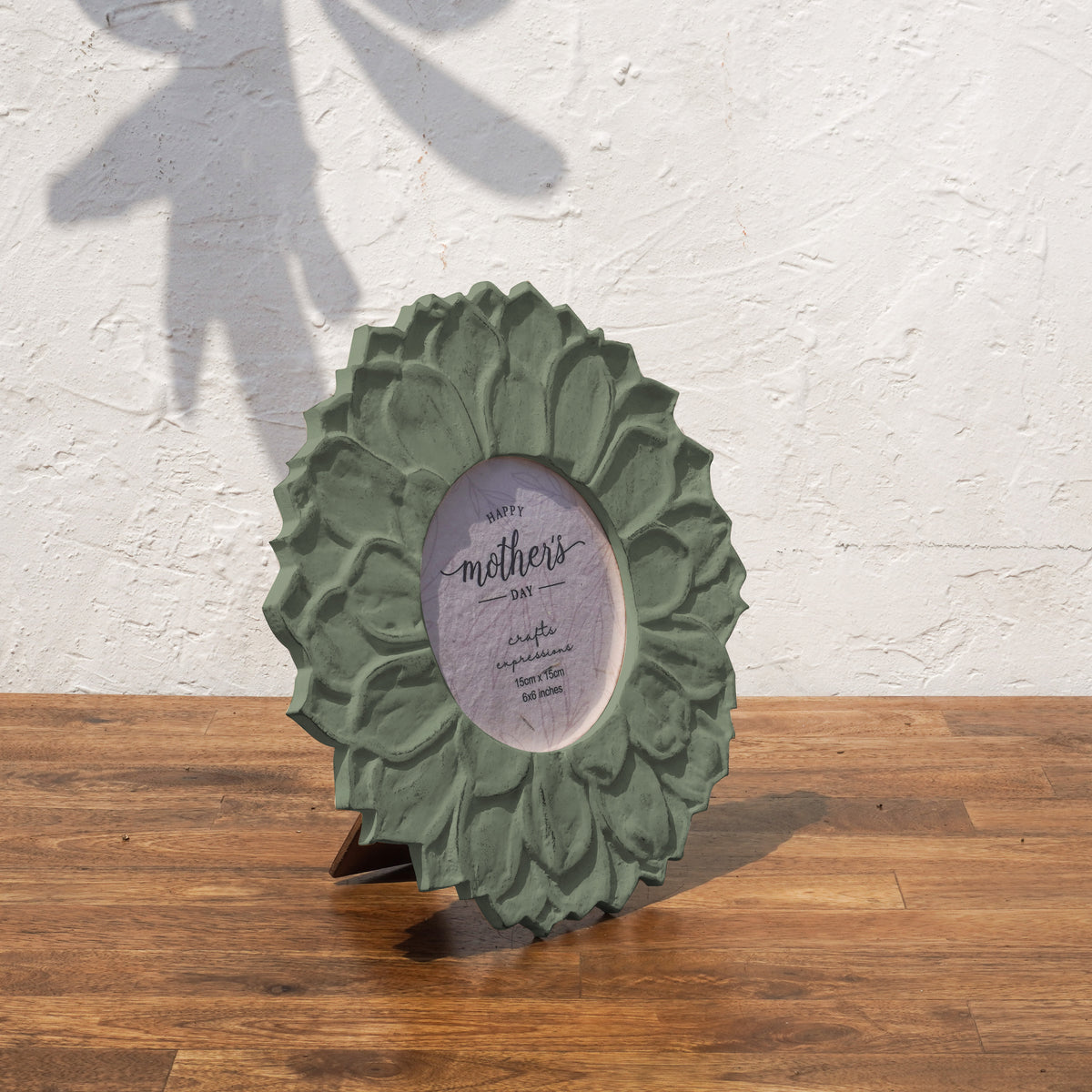 Angled view of the olive green Lotus round photo frame with easel stand