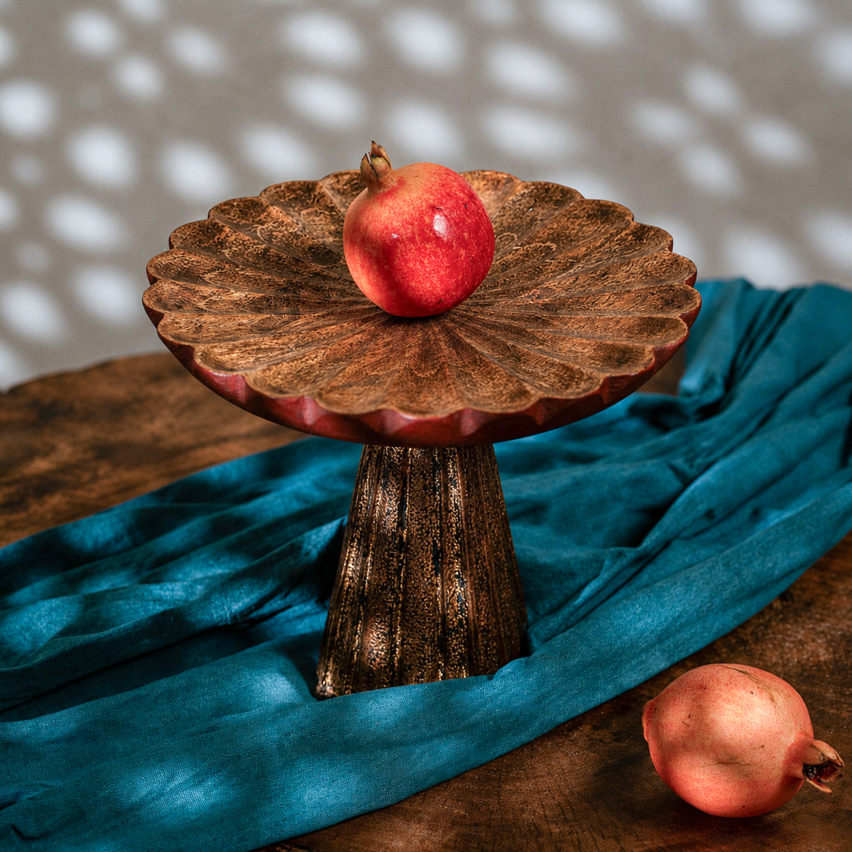 Antique gold and red wooden cake stand with flower-shaped top and tall pedestal