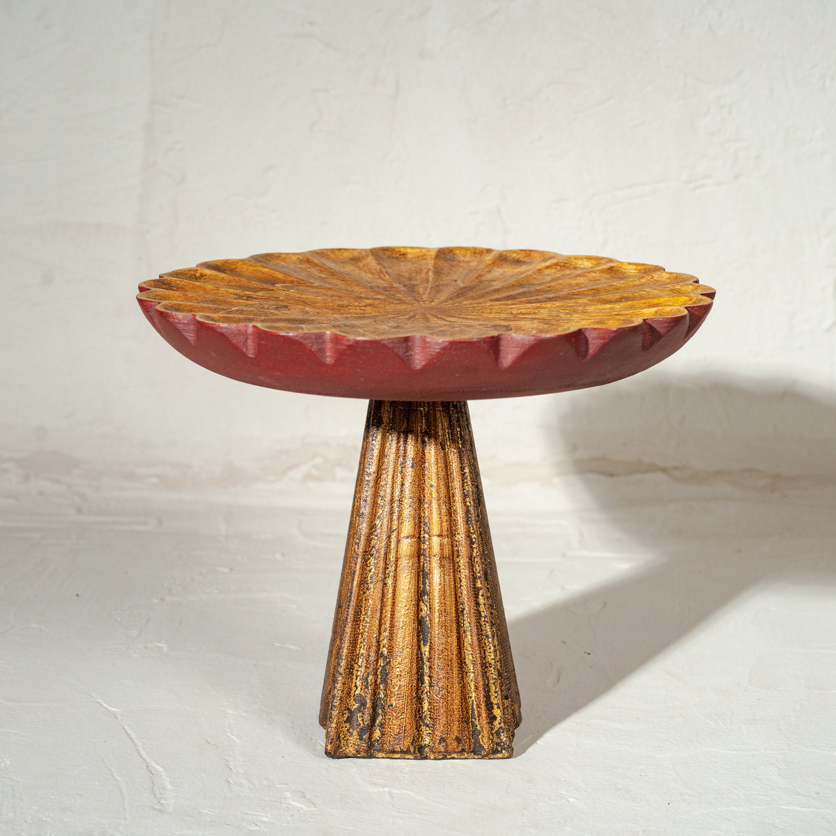 Antique gold and red wooden cake stand with flower-shaped top and tall pedestal