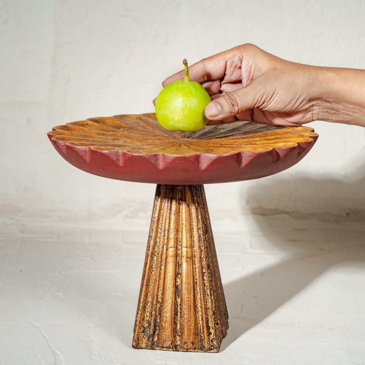 Antique gold and red wooden cake stand with flower-shaped top and tall pedestal