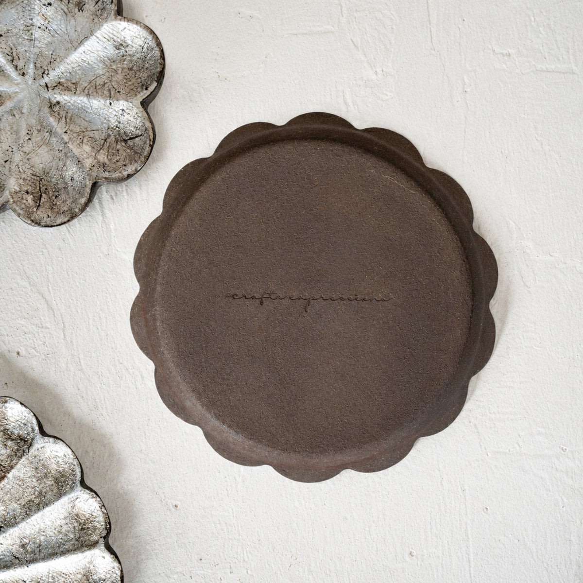 Set of three warm-silver foil flower-shaped wooden serving platters in graduated sizes
