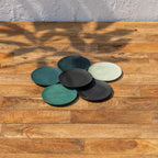 Monsoon wooden coasters spread across a tabletop