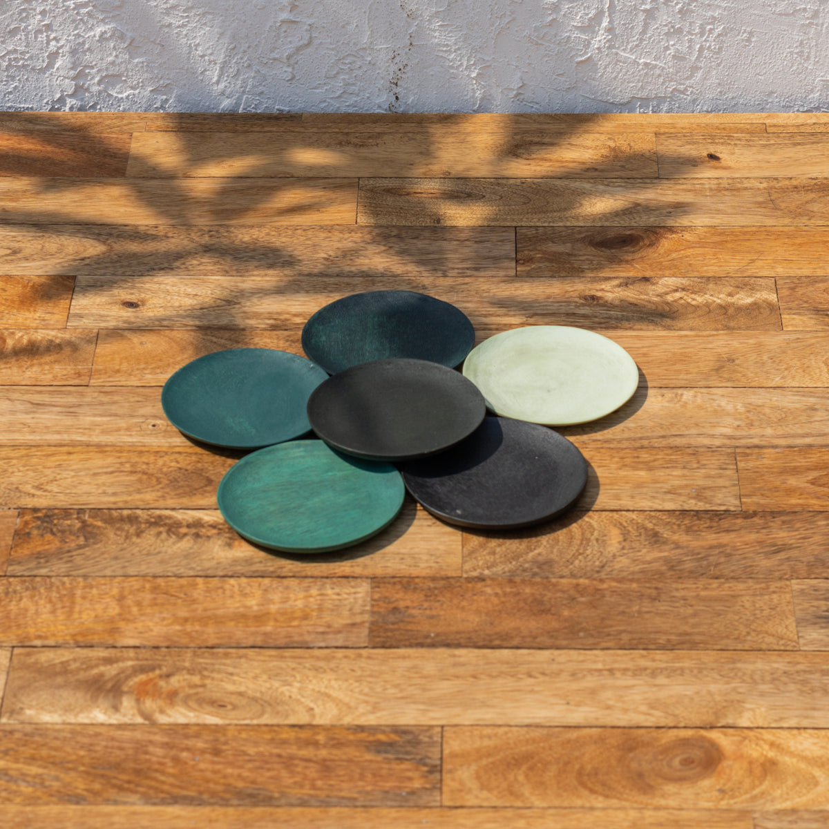 Monsoon wooden coasters spread across a tabletop