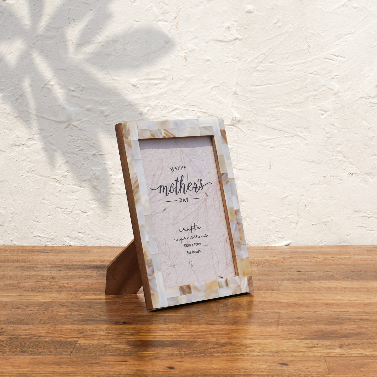 Angled view of the white Mother of Pearl photo frame with easel stand